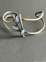 Full view of silver-tone cuff bracelet with three blue glass cabochons