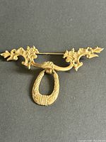 Full view of brass Victorian Revival watch brooch showing bar and hinged drop