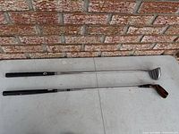 Canox driver and Jackpot putter laid side by side on table, full length view