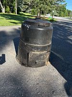 Front view of full compost bin showing lid, body, base door and ventilation slots