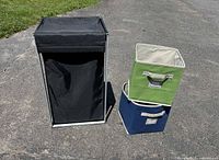 hamper and two storage cubes standing on pavement
