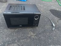 Front and side view of the black High Pointe countertop microwave with attached power cord
