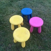 Four plastic stools on grass showing overall colors and quantity