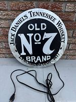 Front view of circular Jack Daniel's neon sign with attached power cord visible