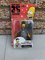 Front view of sealed Homer Simpson Coach figure in packaging