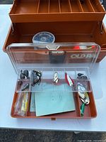 Open tackle box showing clear organizer with lures, sinkers, chain; spool of fishing line visible; Old Pal branding on box interior