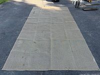 Full view of tan mesh rug laid flat showing size and overall condition