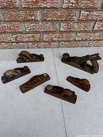 All seven planes on tabletop against brick wall
