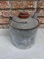 Front angled view of galvanized oil can showing spout, handle, cap and overall condition