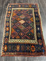 Full view of Persian Ghashghayi rug showing entire design and size