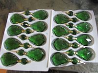 Sixteen emerald green prisms in packing trays