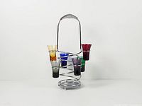 Full view of set showing six coloured glasses seated in chrome spiral caddy
