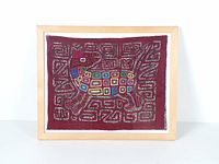 Full view of framed mola textile on white background
