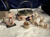 Group shot of mask, biscuit barrel, cherubs, flower basket