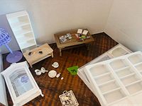 Overall view of dollhouse furniture and accessories arranged on surface