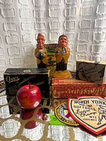 Overview of lot showing figurines, boxed items, apple and patches