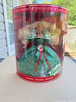 Front view of unopened Barbie Happy Holidays 1995 doll in cylindrical display packaging