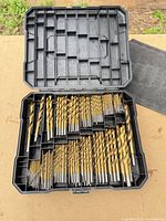 Open case showing full assortment of gold-tone drill bits