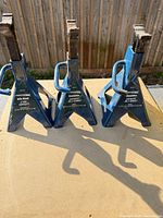 Three blue Certified axle/jack stands on table