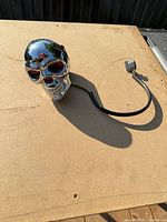 Front view of chrome skull hitch cover showing red eye lenses and wiring