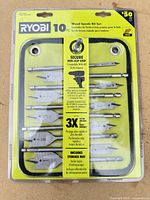 Front view of sealed Ryobi 10-piece wood spade bit set in packaging
