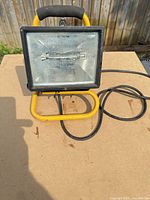Front view of halogen work lamp showing glass lens and stand