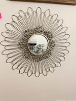 Front view showing entire sunburst mirror design and central reflective surface
