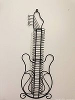 Full view of guitar-shaped black metal CD/DVD rack