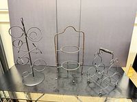 All three wrought iron bottle racks displayed together