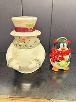 Front view of snowman cookie jar and penguin figurine