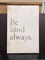 Front view of rustic white wall sign with gray text