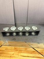 full view of wooden base with five glass cups