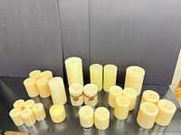 All 25 assorted size ivory and cream pillar candles displayed upright