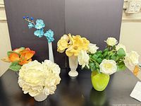 Group shot of all five faux flower arrangements and their vases
