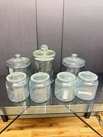 Front view showing all seven clear glass storage jars with matching lids
