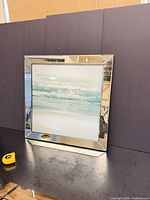 Front view of square mirrored framed abstract seascape art