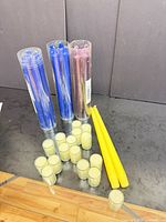 Three tubes of blue and purple taper candles, two loose yellow tapers, cluster of cream votive candles