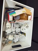 Bin showing assorted boxed and loose CFL, LED and incandescent bulbs