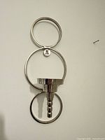 Front view of chrome-plated stainless steel wall sconce with three rings and central candle cup