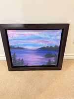 Framed acrylic landscape painting with purple, blue, pink sky over water and tree silhouettes