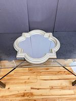 Front view of quatrefoil wall mirror on glass table