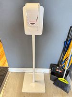 Full view of freestanding sanitizer dispenser on metal stand with square base
