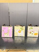 Front view of three safari animal gift bags showing designs and ribbon handles