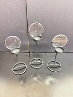 Front view of three black metal tealight holders showing design and height variation