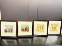 All four framed prints side by side on surface