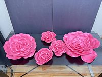 Front view of all five pink foam flowers displaying size variation