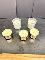 Front and top view of all five votive candles showing holder materials and wax color