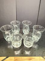 Six green-tinted clear glass holders displayed; three tall, three short