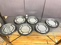 Seven identical round mirrors displayed on tabletop