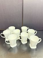 Front view of all eight white ceramic mugs